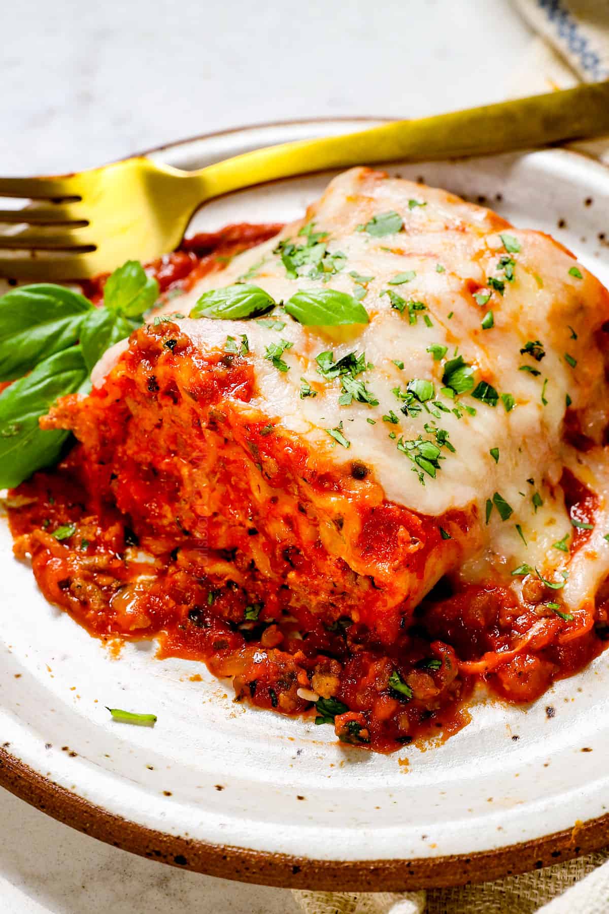 showing how to serve lasagna roll ups with a single roll on a plate