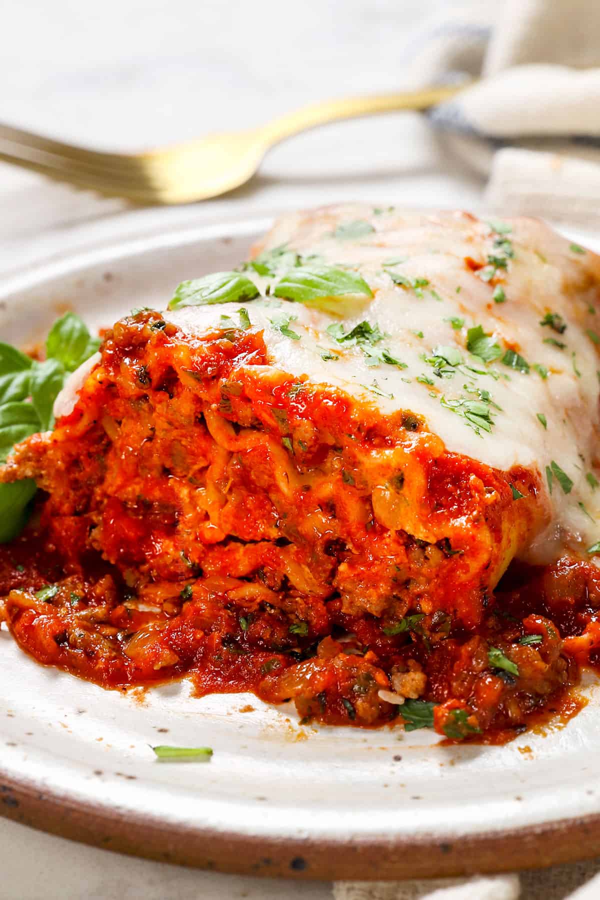 serving lasagna roll up recipe on a plate with sauce