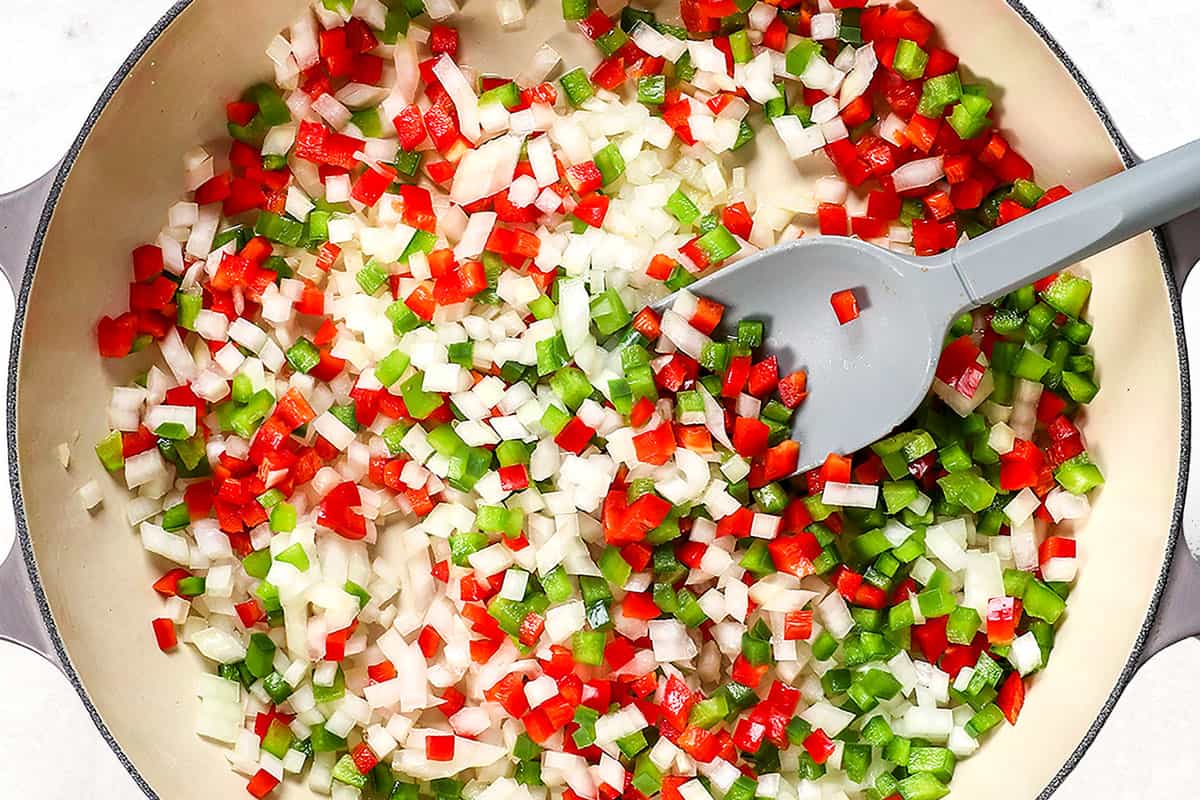 showing how to make shakshuka by sautรฉing onions and bell peppers