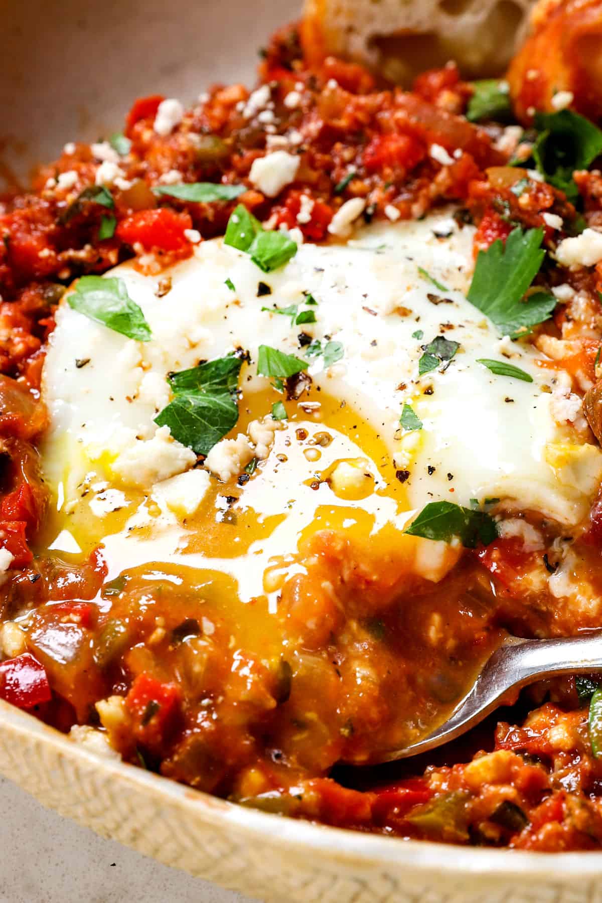 up close of eating eggs shakshuka showing the runny yolk