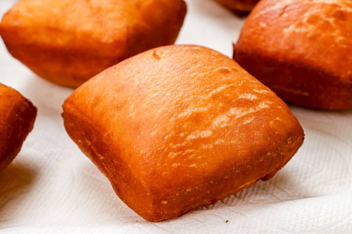 showing how to make beignets by draining beignet on a paper towel