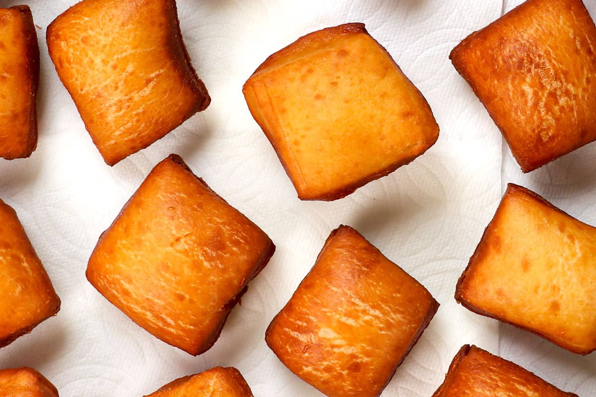 showing how to make beignets by draining beignet on a paper towel
