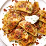 top view of pierogi recipe being served on a plate with sour cream