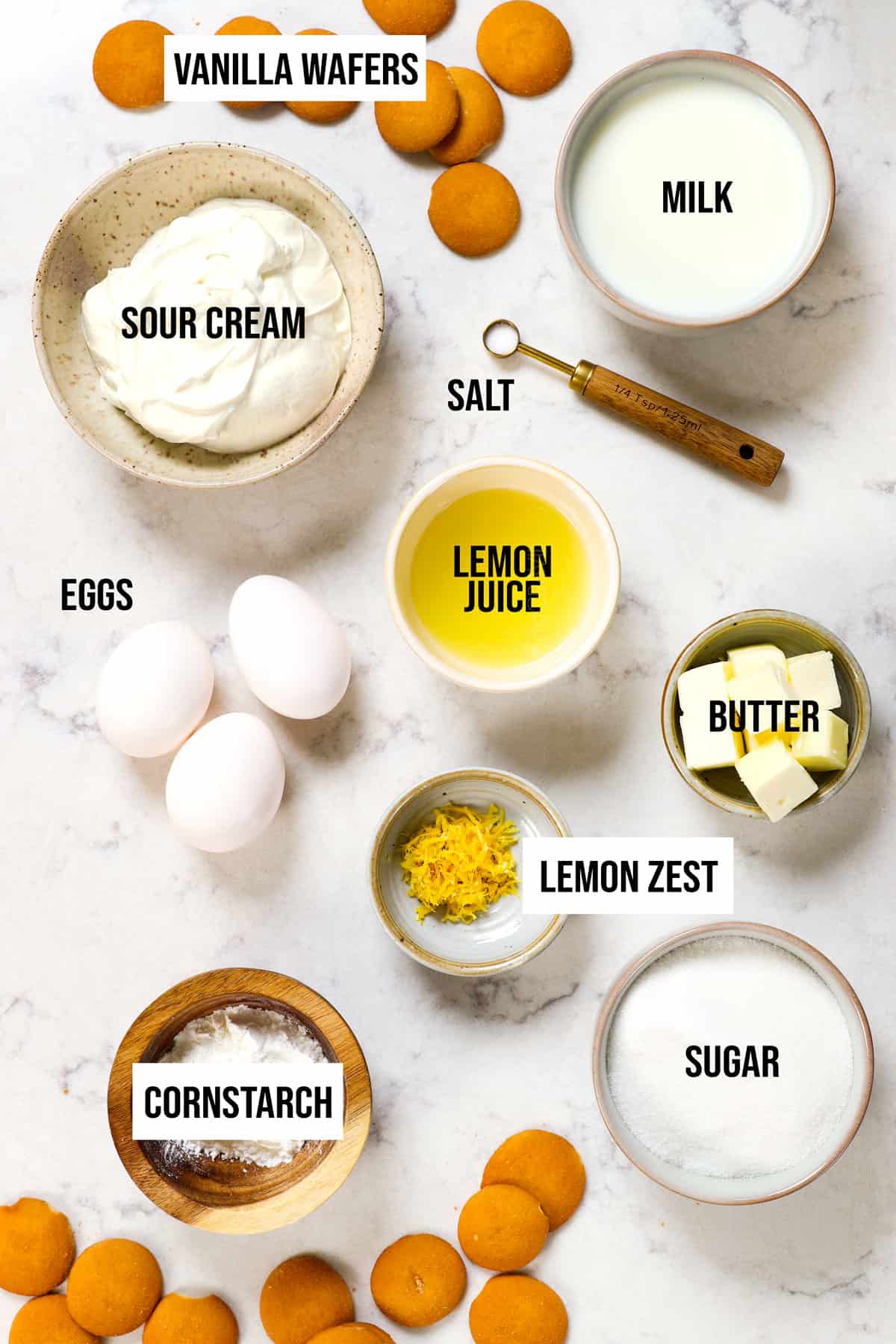 top view of lemon pie ingredients: lemon juice, lemon zest, cornstarch, sugar, butter, eggs and sour cream