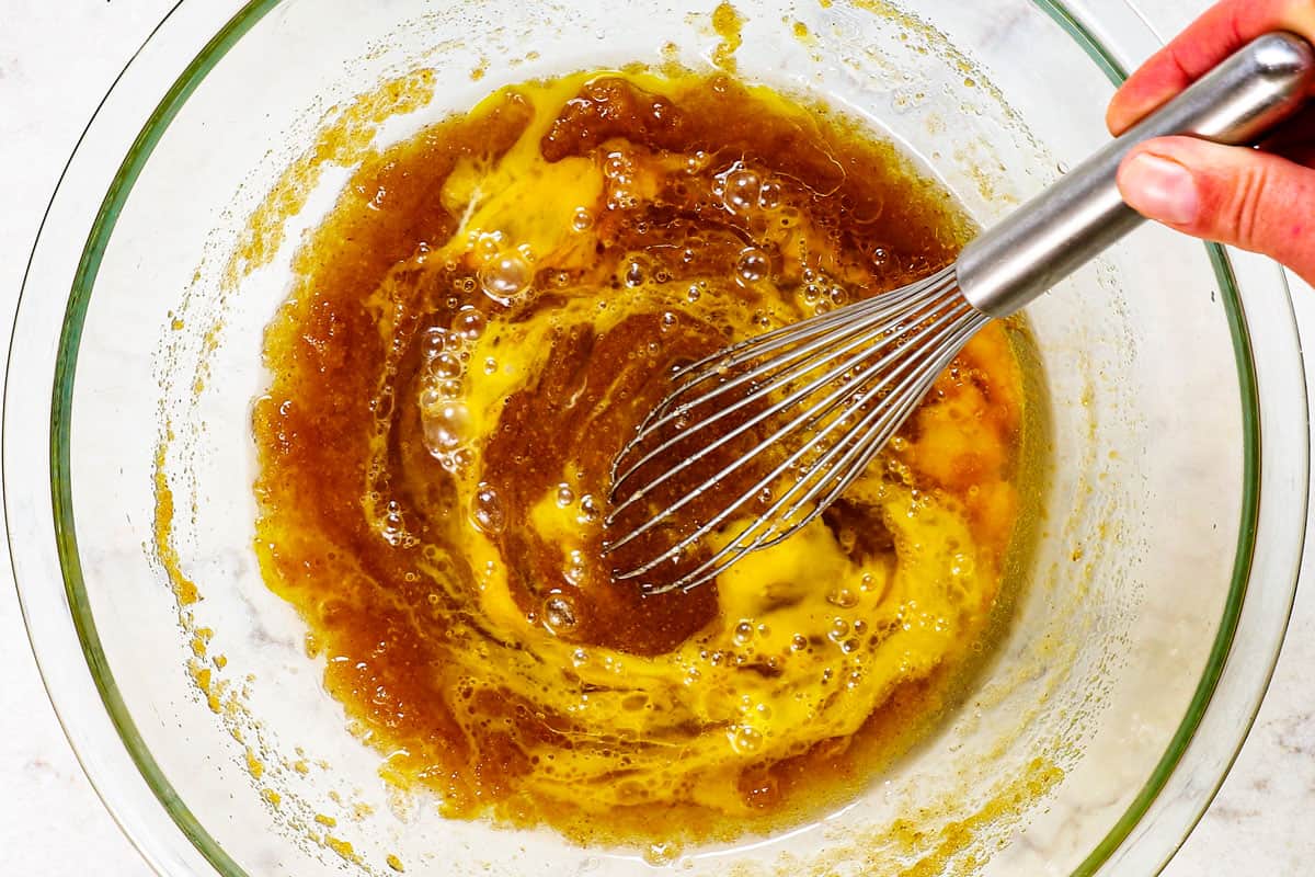 showing how to make pizookie by whisking eggs with butter, followed by dry ingredients