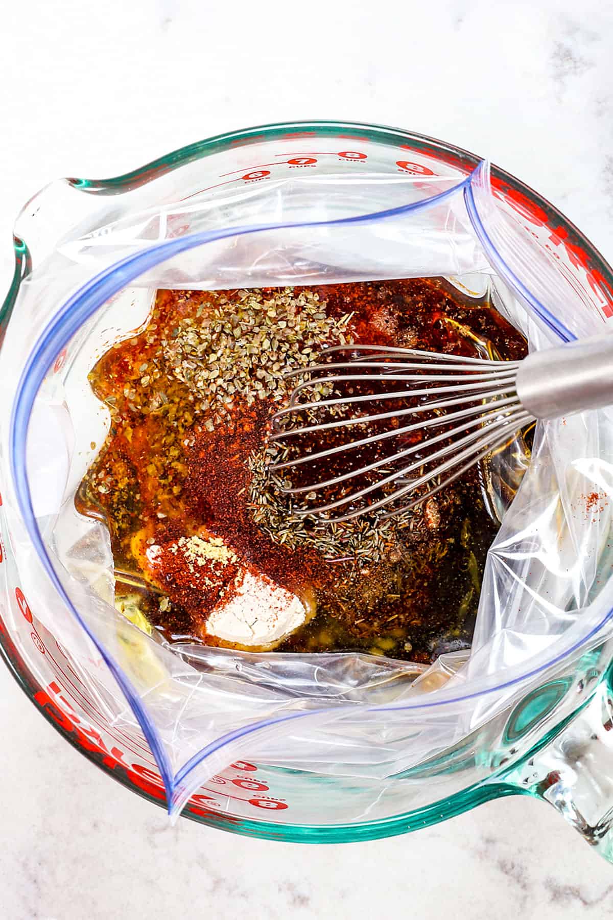 showing how to make steak marinade by whisking soy sauce, balsamic vinegar, Worcestershire, and spices together in a freezer plastic bag