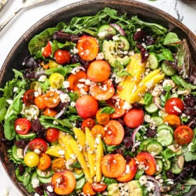 top view of summer salad with cherries, peaches, mangos, avocado and tomatoes