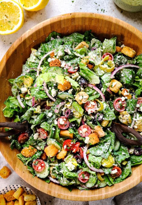 showing how to make Mediterranean salad recipe by tossing the salad together