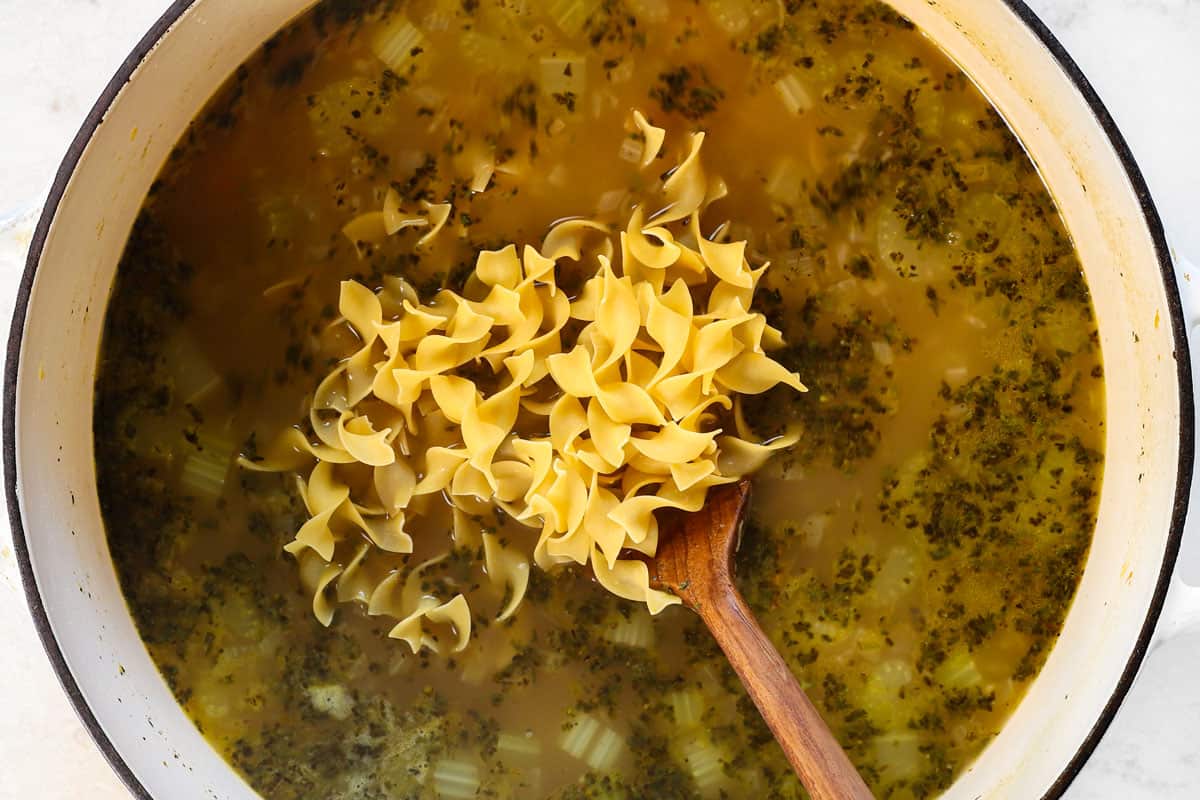 showing how to make turkey soup by adding the egg noodles and simmering