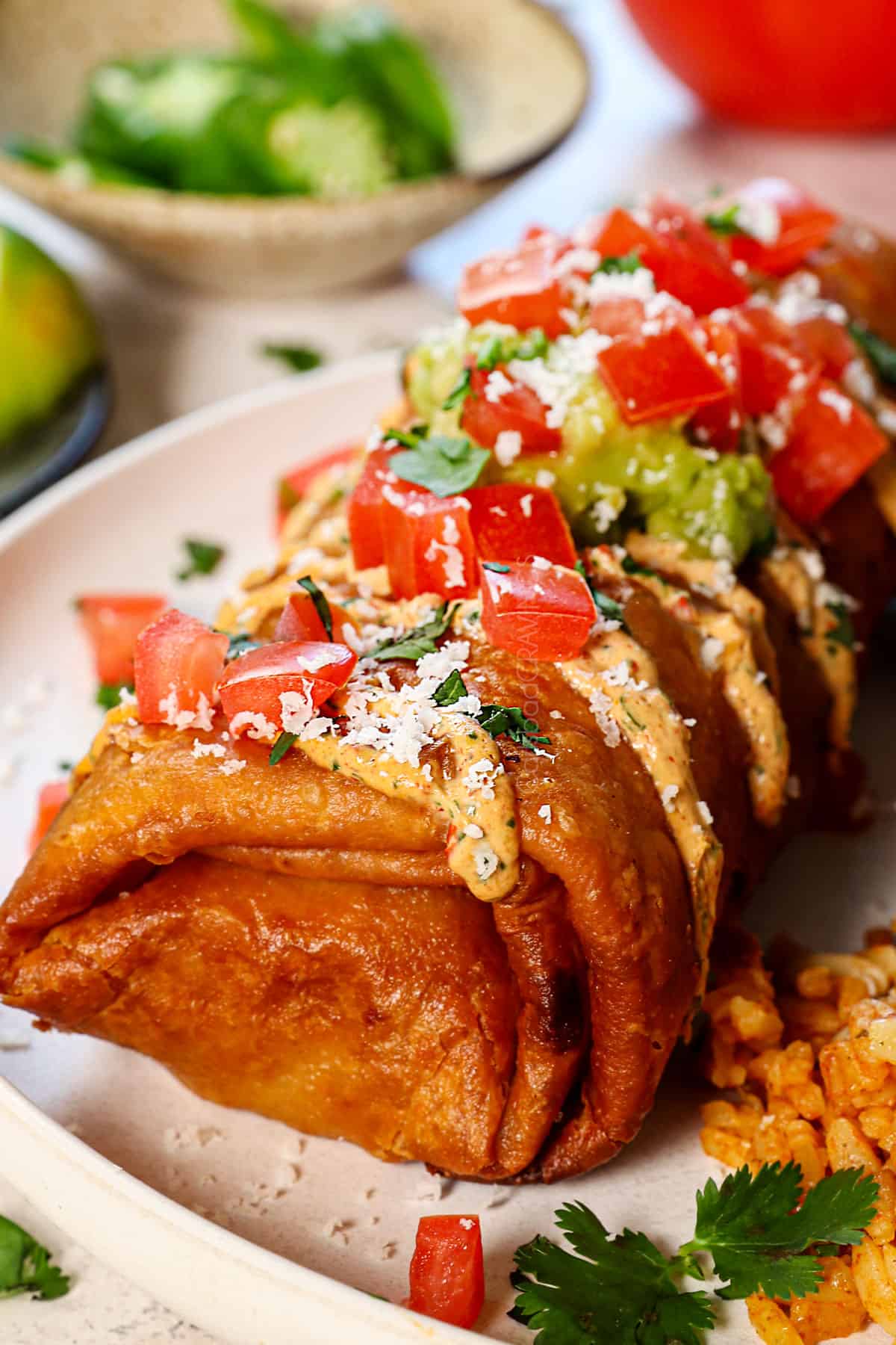 serving chicken chimichanga on a plate with Mexican rice and refried beans