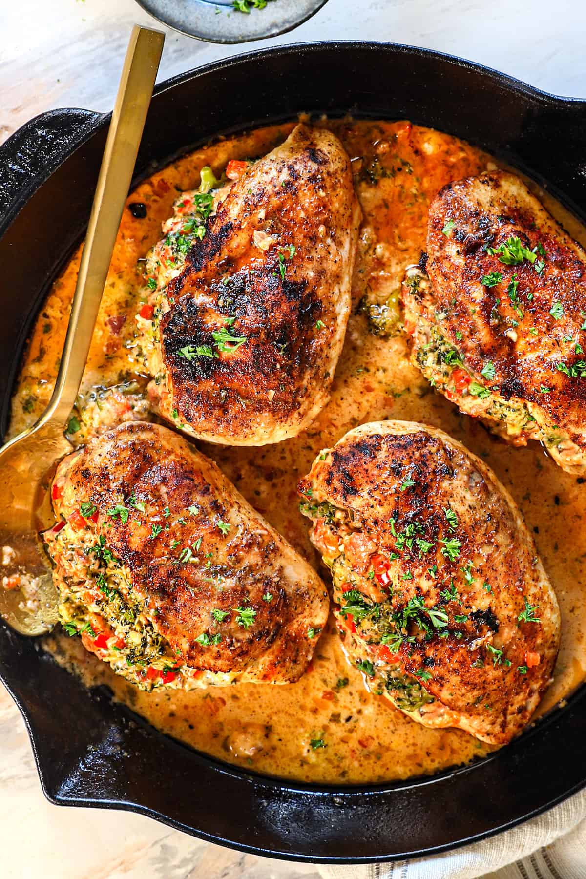 top view of stuffed chicken breast in a skillet showing the pan sauce