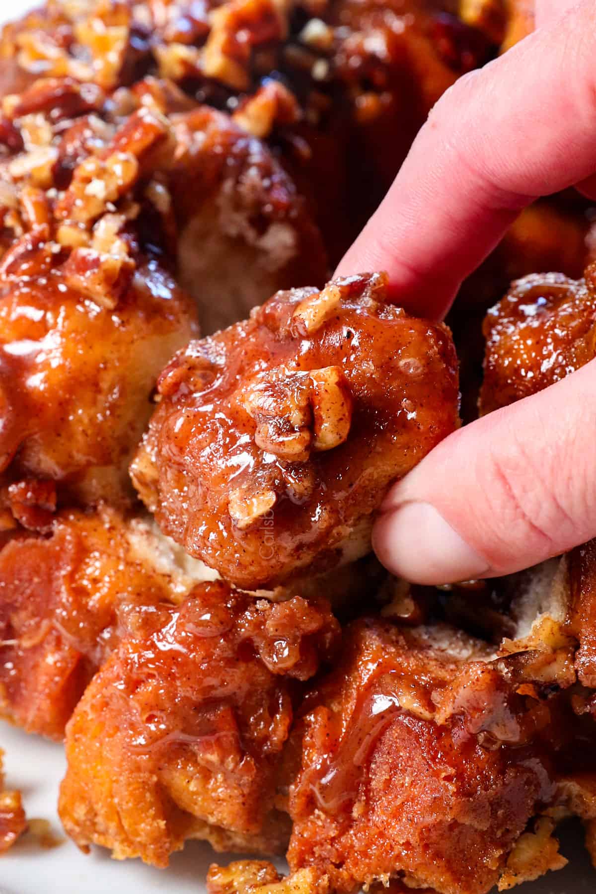 up close picking up a piece of monkey bread showing the softness and stickiness