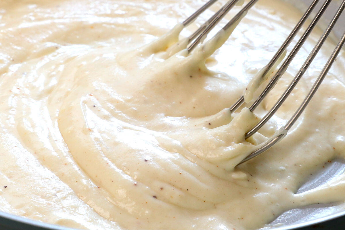 showing how to make croque monsieur by simmering the bรฉchamel until thickened