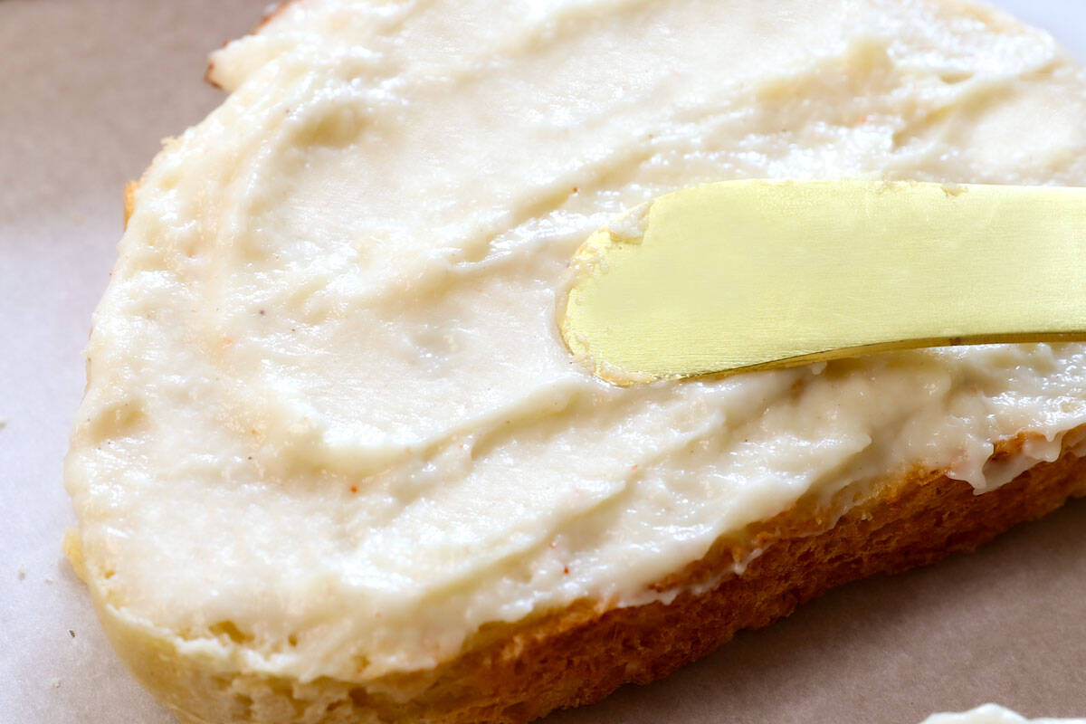 showing how to make croque monsieur by spreading the bottom of the bread with bรฉchamel