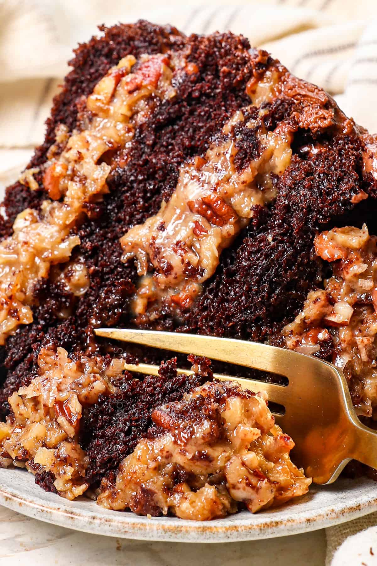 a slice of homemade German chocolate cake on a plate showing how tender the cake is