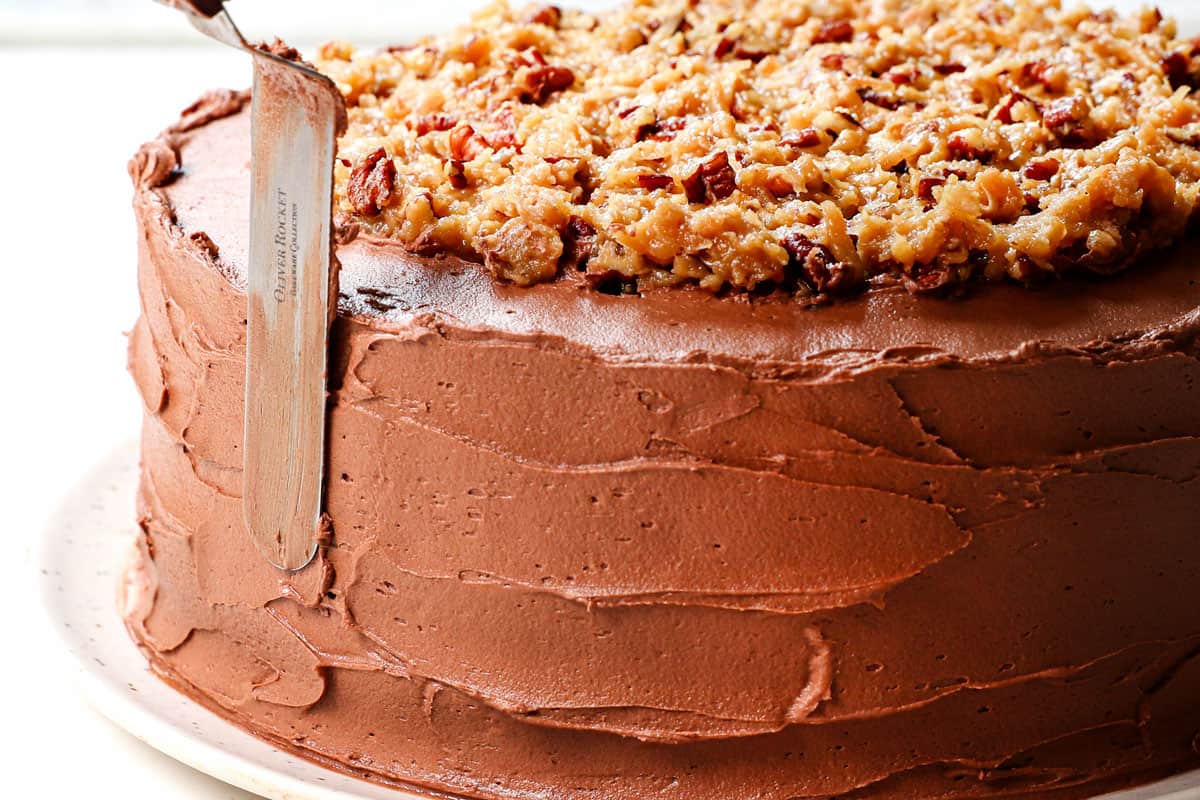 showing how to make German Chocolate by frosting the entire cake with chocolate buttercream frosting