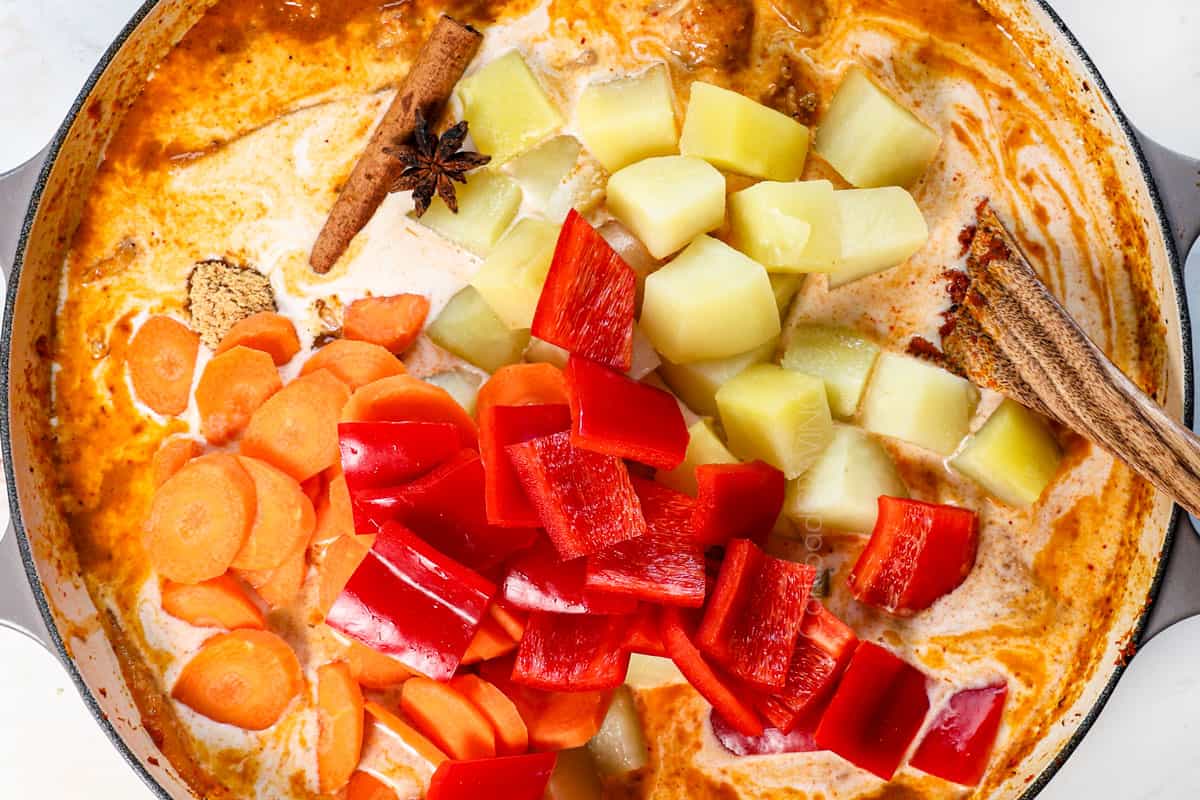 showing how to make massaman curry by adding the potatoes, carrots, bell pepper, fish sauce, soy sauce, palm sugar, peanuts, cinnamon, and star anise.