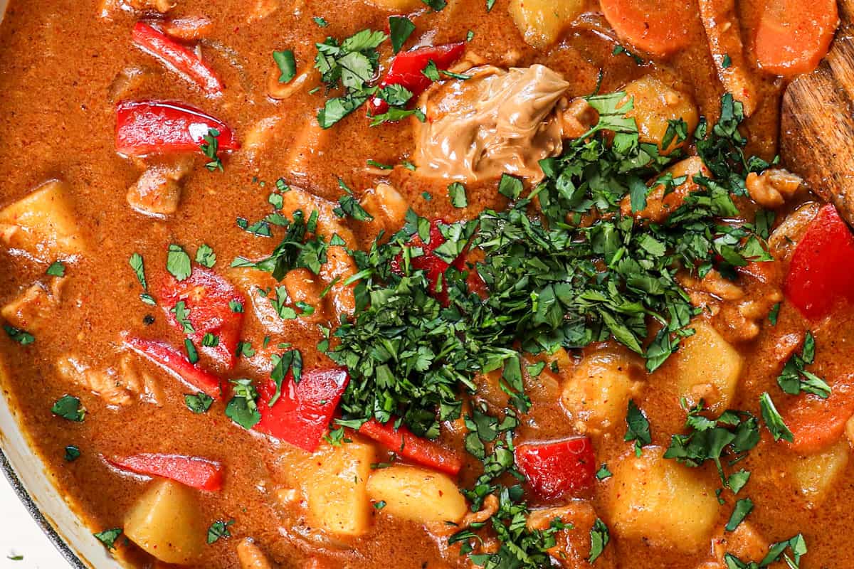 showing how to make massaman curry by stirring in the lime juice, peanut butter, and cilantro