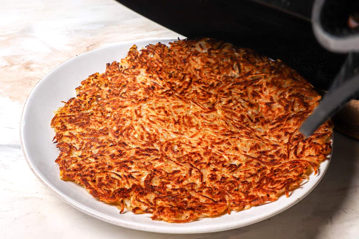 showing how to make hash browns by flipping the hashbrowns onto a plate before cooking the other side