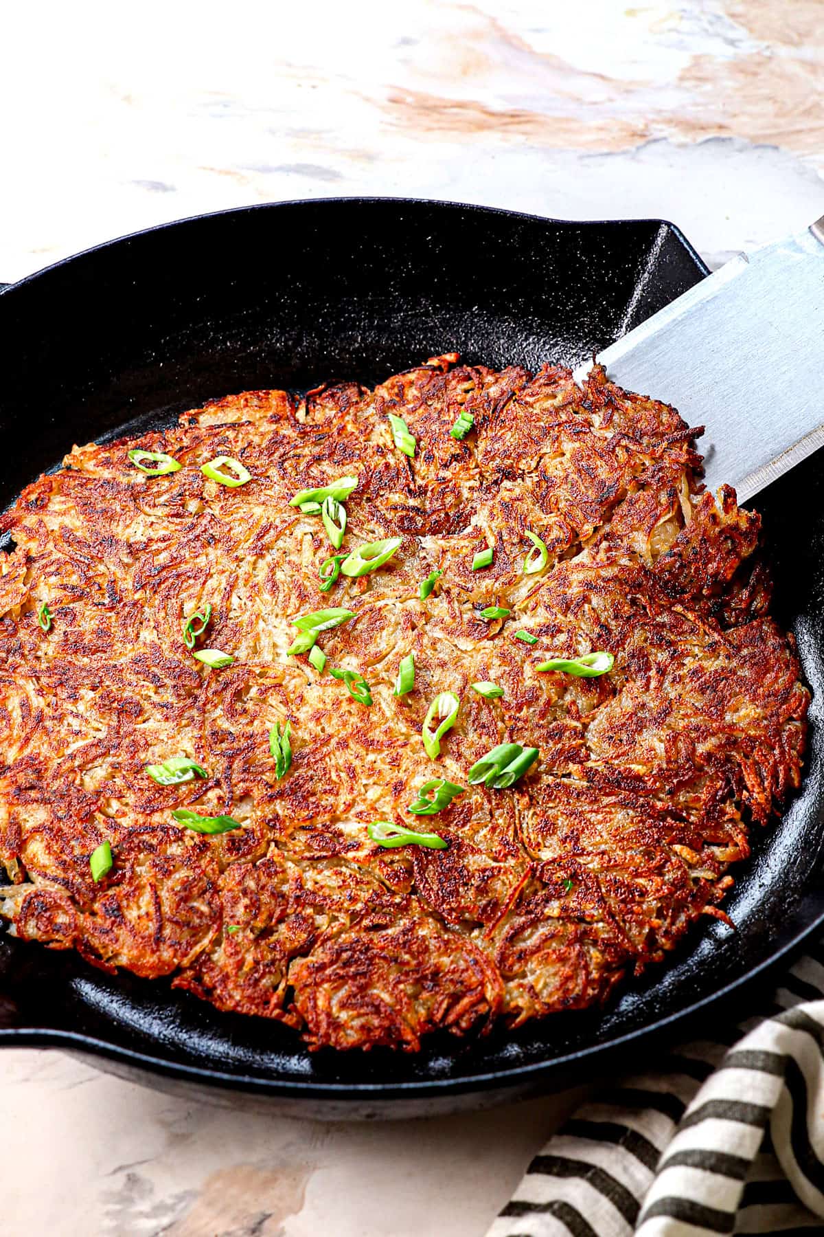 hash brown recipe in a skillet showing how crispy it is