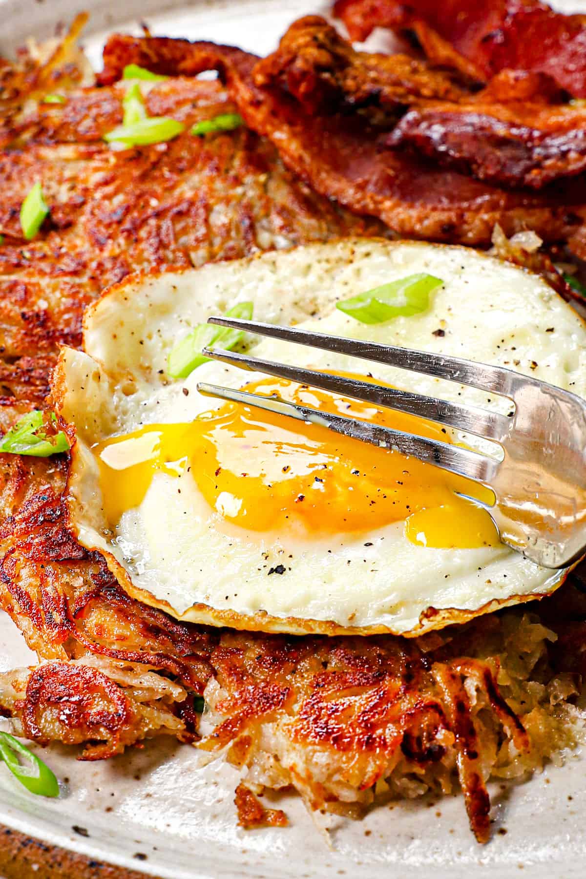 showing how to eat hash browns recipe by taking a bite of hashbrowns and egg