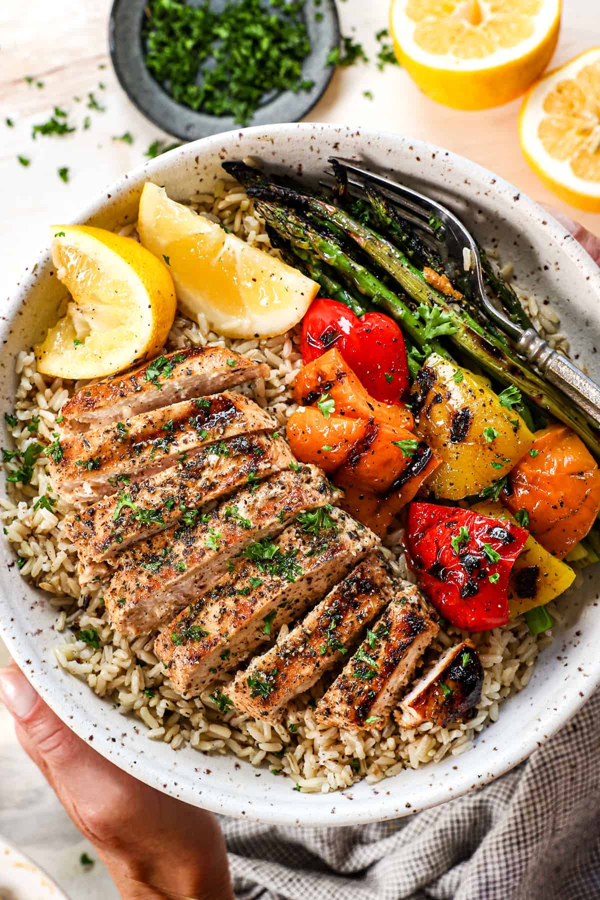 showing how to serve best grilled chicken recipe on a plate with rice and grilled vegetables