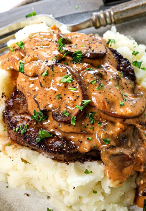 Beef Steak Diane Recipe being served over mashed potatoes, showing how creamy the gravy is