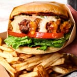 up close of holding a burger with burger sauce dripping down