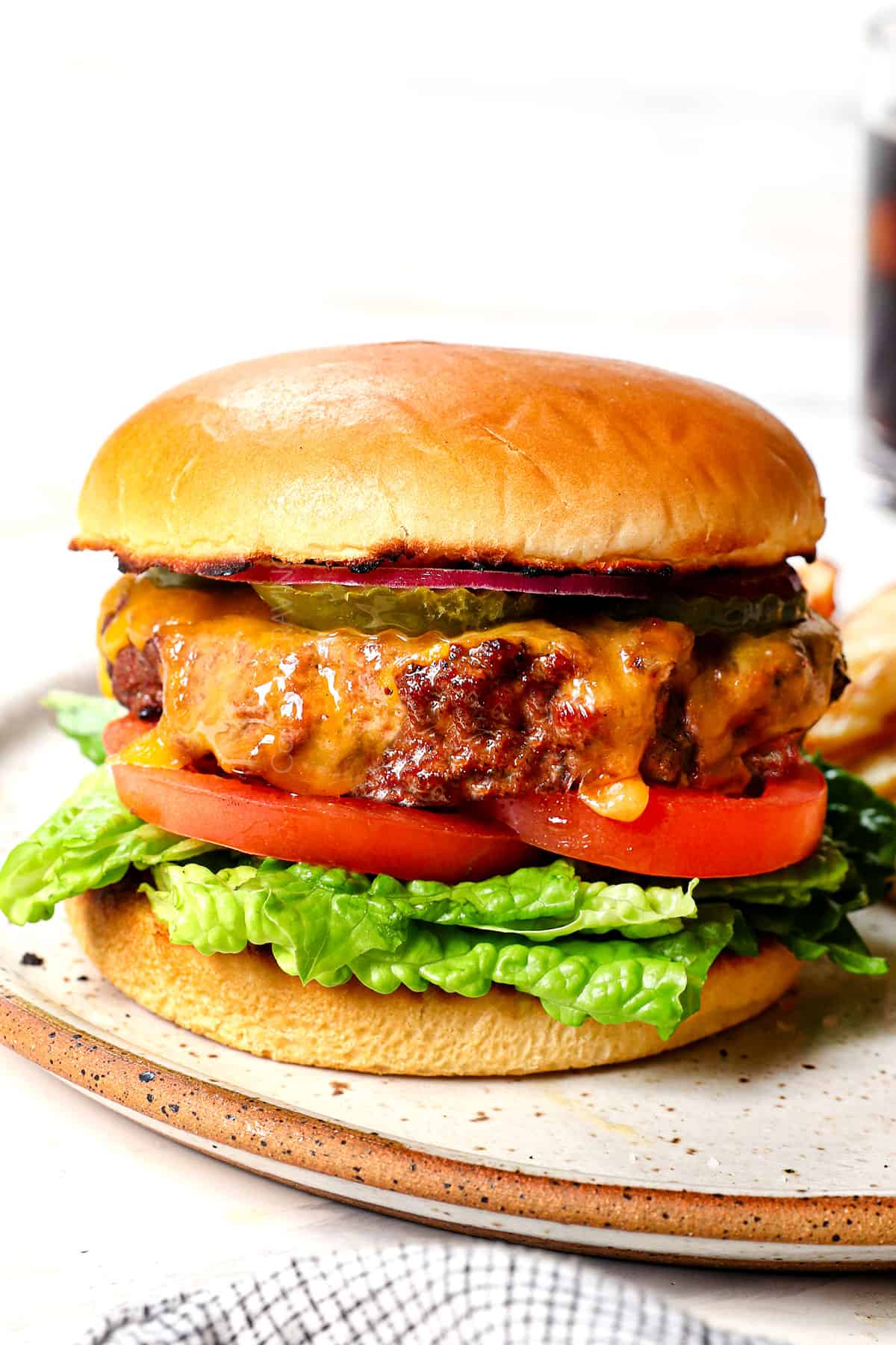 up close of cheeseburger recipe on a plate showing how to plate the burger
