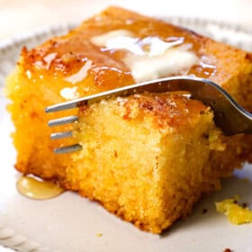 up close of a fork taking a bite out of homemade cornbread, showing how moist it is