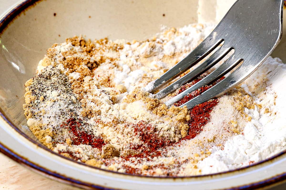 showing how to cook chicken thighs in air fryer by mixing the spices together in a bowl