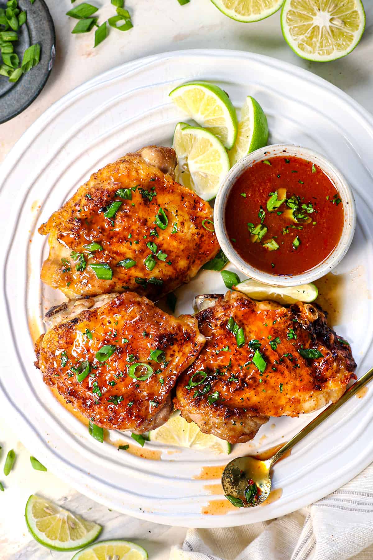 top view of chicken thighs in air fryer garnished with green onions