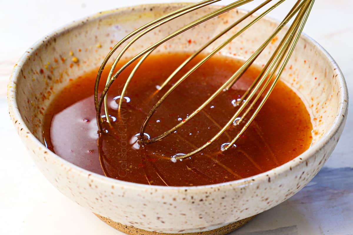showing how to cook chicken thighs in air fryer by whisking the glaze ingredients together in a bowl