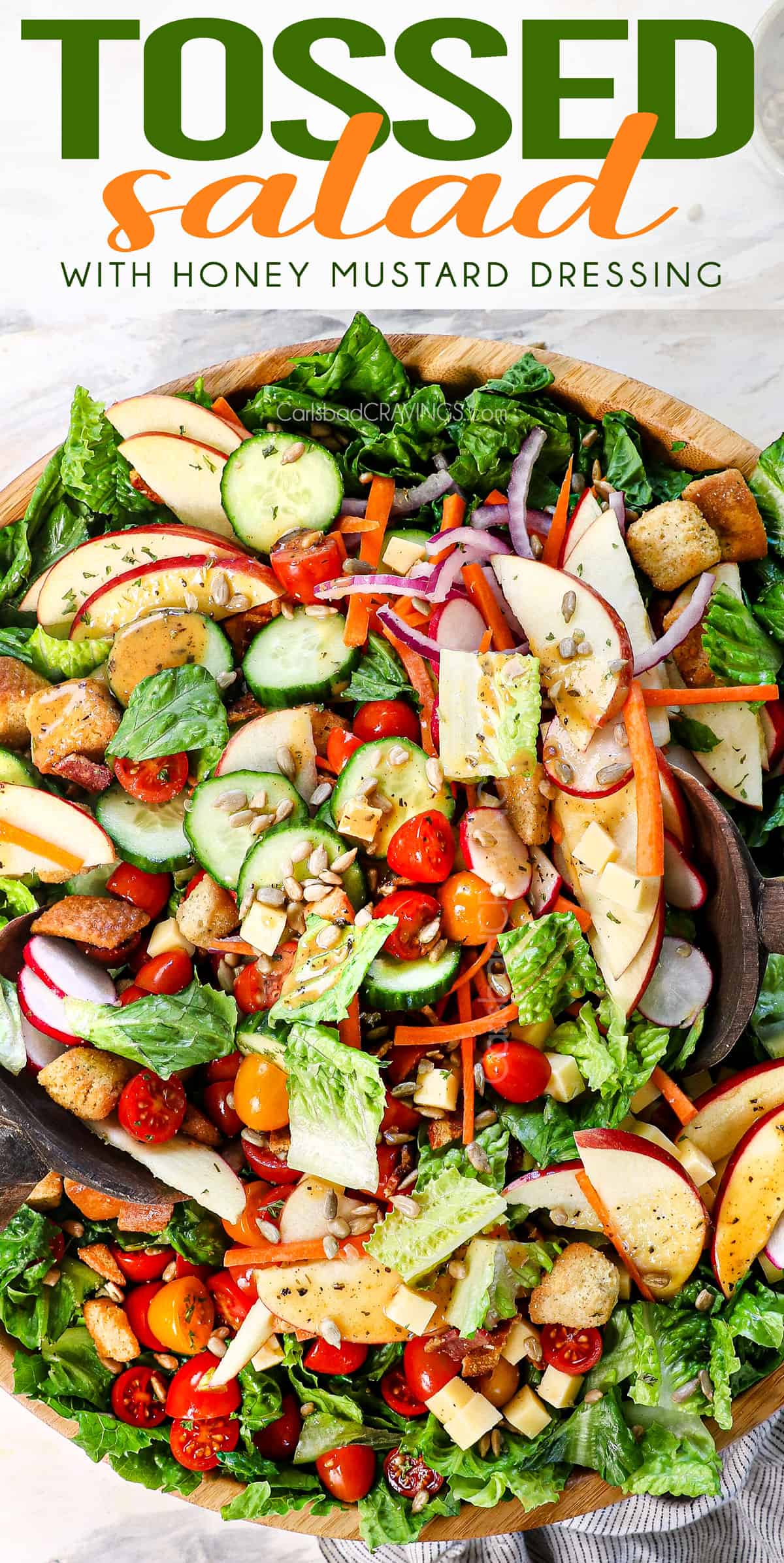 up close top view of tossed salad in a bowl being tossed with tongs