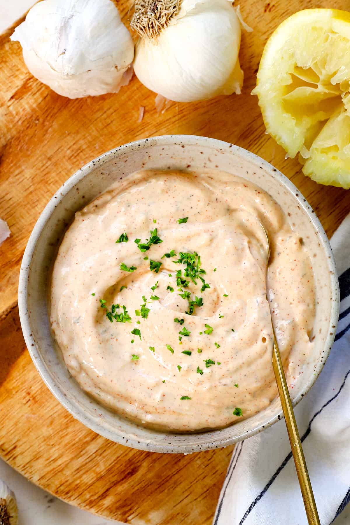 showing how to make garlic aioli by seasoning to taste with salt and pepper