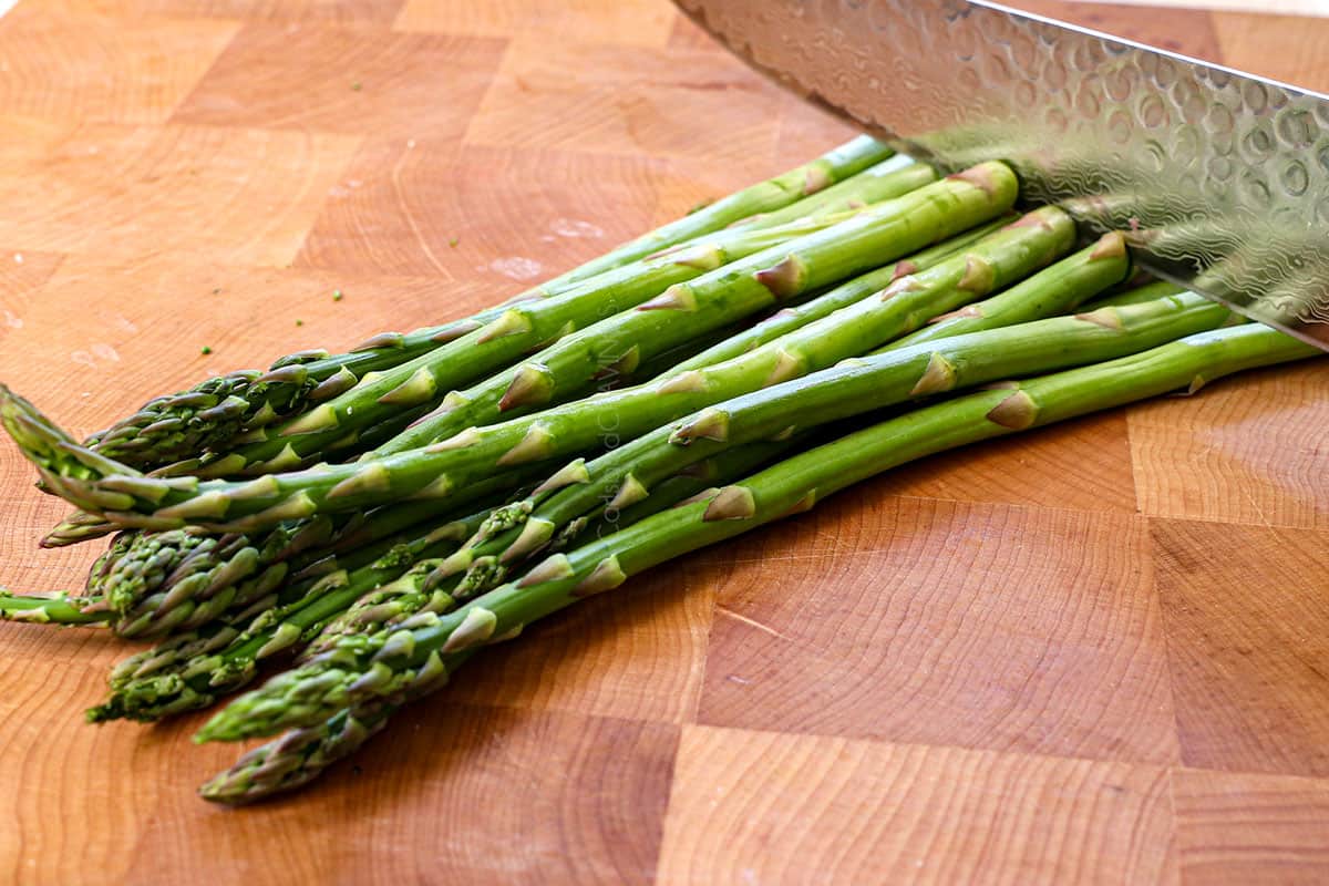 showing how to grill asparagus by chopping the woody ends off