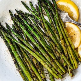 showing how to grill asparagus by transferring it to a platter after grilling