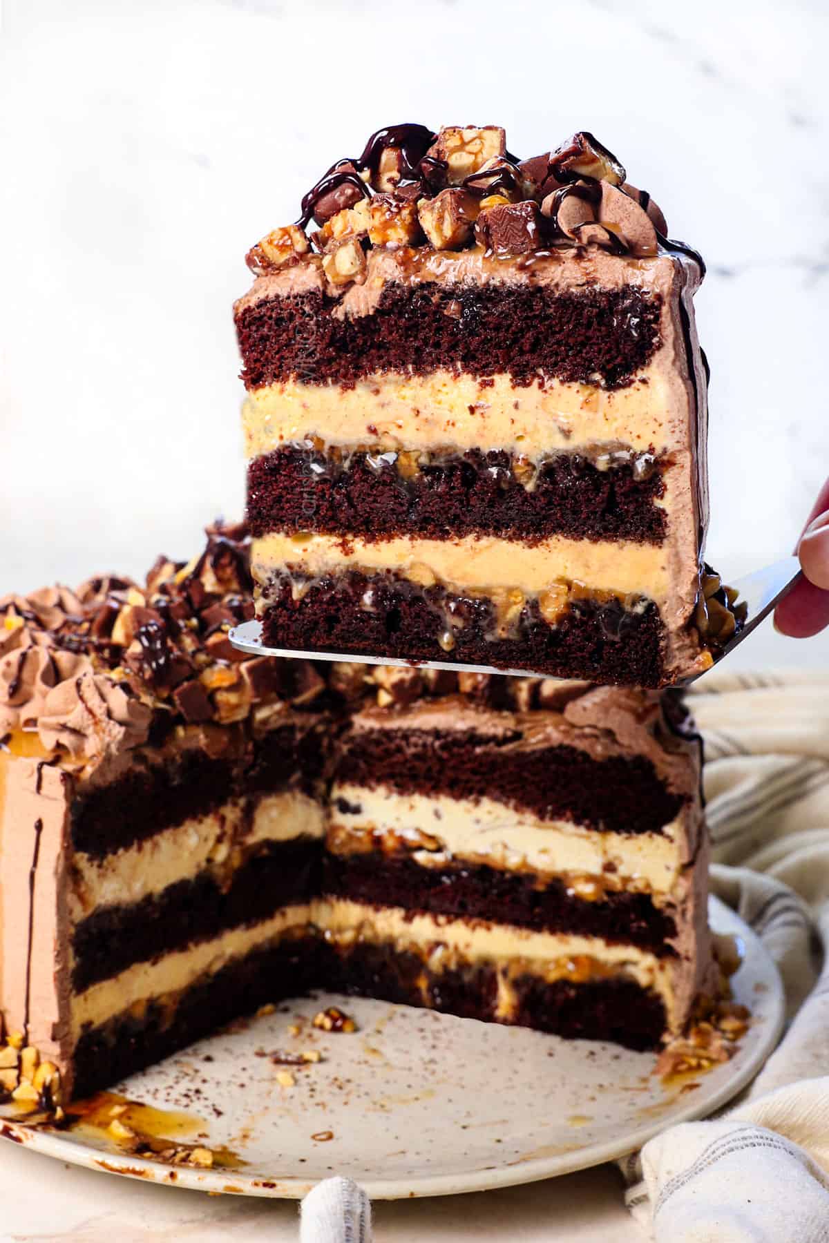 holding up a slice of the best ice cream cake showing the different layers