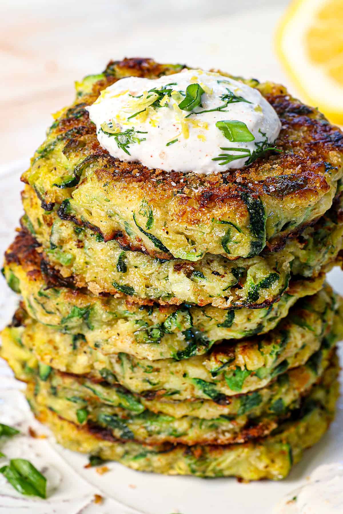 a stack of zucchini fritters served with a dollop of yogurt