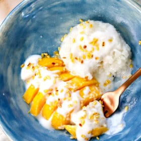 Top view of mango sticky rice being served topped with toasted, crispy mung beans