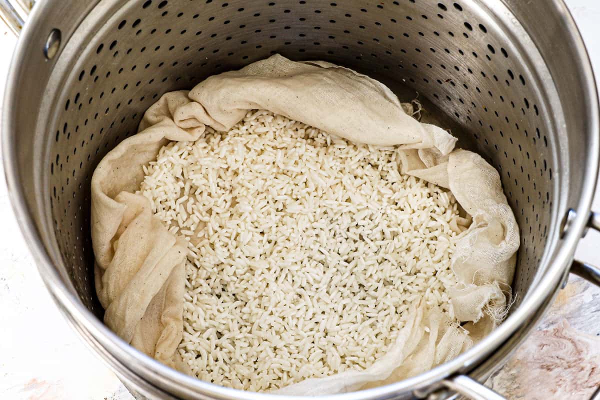 showing how to make mango sticky rice by steaming the rice in a cheesecloth in a steamer basket