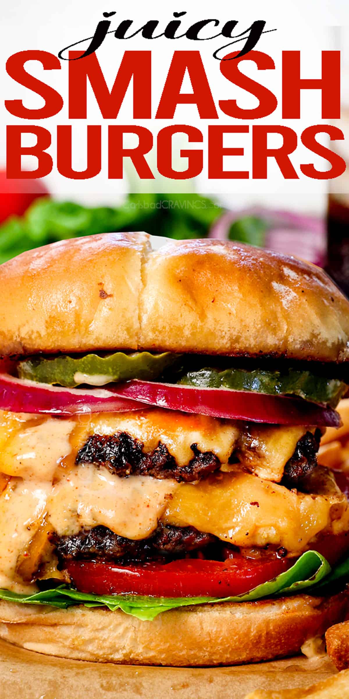 up close of a smash burger showing the juicy burger with crispy edges and the melty juicy and toppings: tomatoes lettuce, red onion, pickles and smash burger sauce