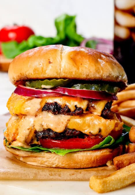 best smash burger recipe with cheese on a cutting board with fries