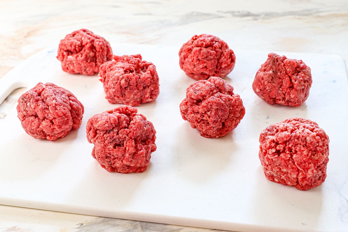 showing how to make smash burgers by forming the ground beef into 8 loose balls