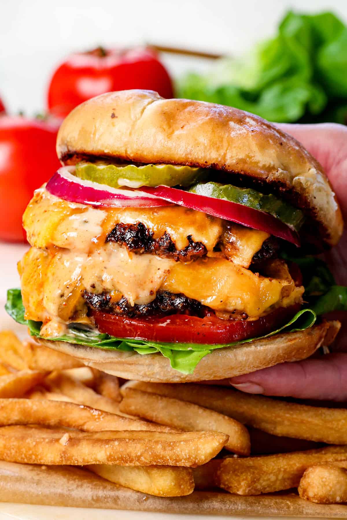 picking up a smash burger showing the crispy edges and melty cheese