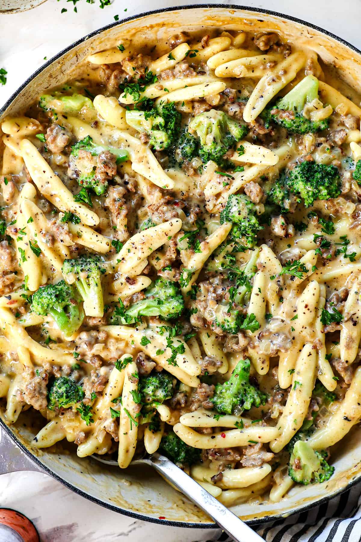 showing how to make cavatelli by garnishing with fresh parsley and freshly cracked pepper