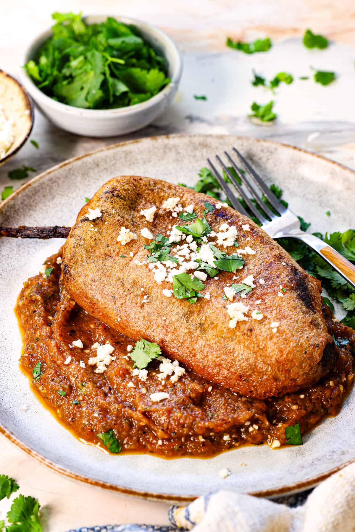 chile rellenos recipe being served on a plate with fresh salsa