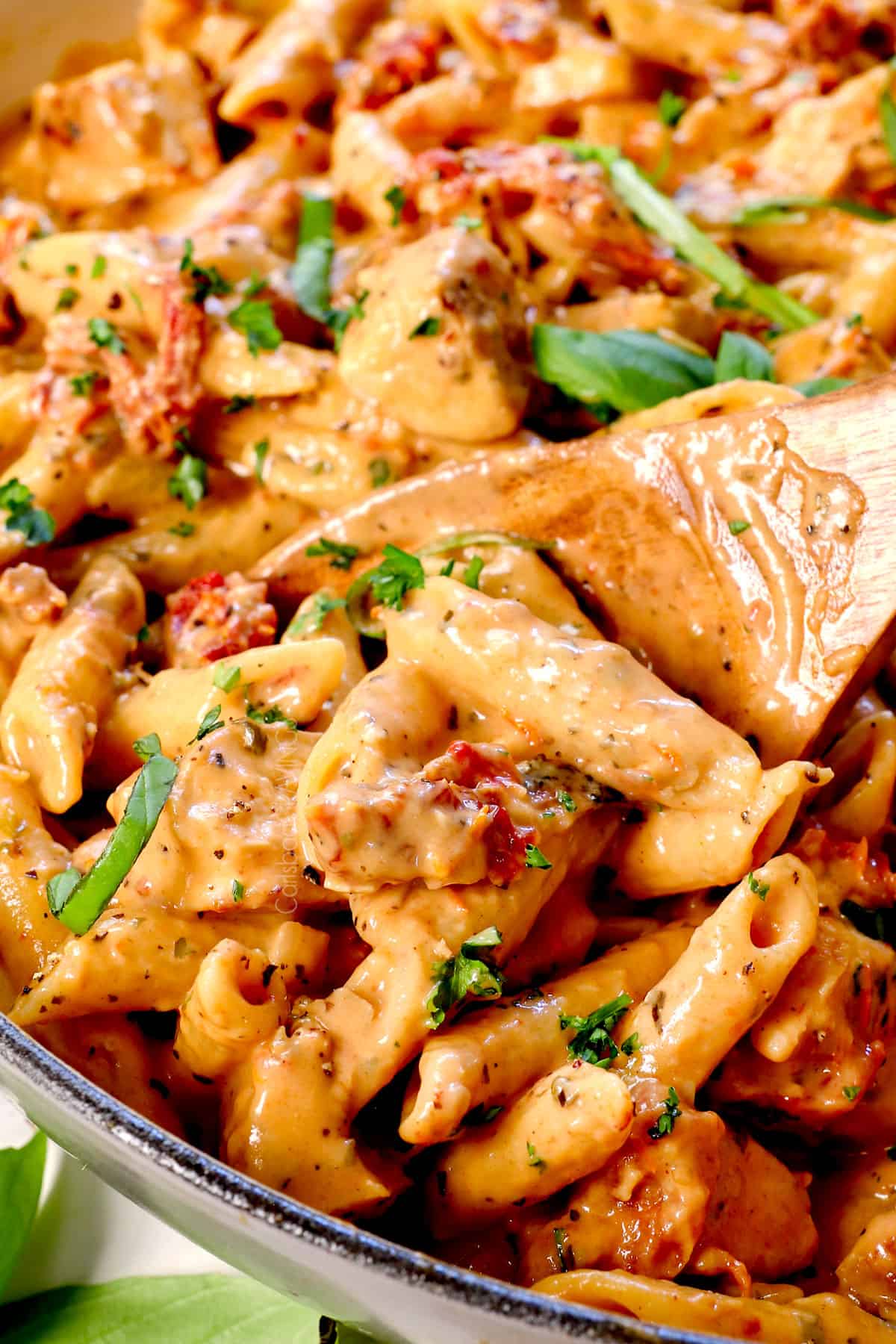up close of scooping marry me chicken showing the juicy chicken and sun dried tomatoes in a creamy, rich sauce