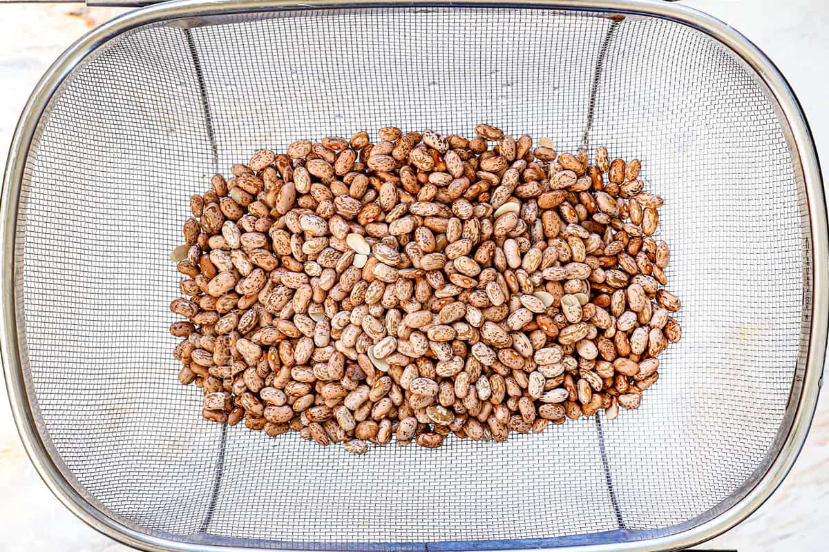 showing how to make refried beans by rinsing the beans in a strainer and picking over for any debris