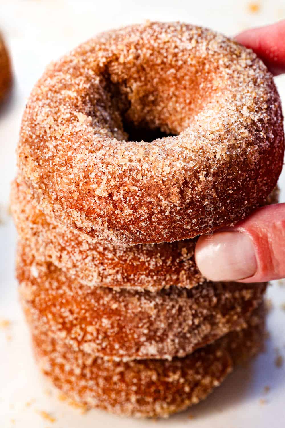 picking up an apple cider donut to show its fluffy texture